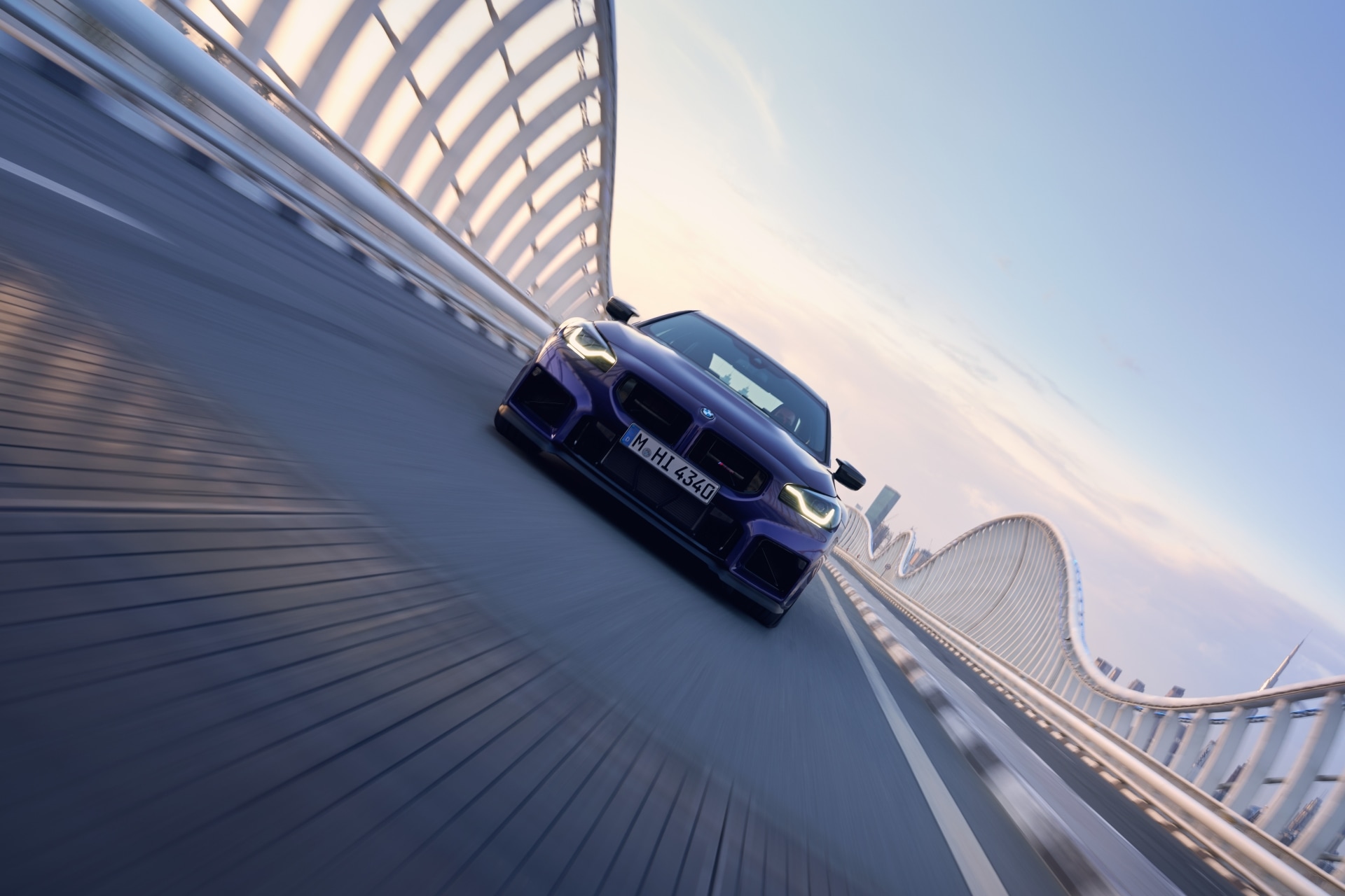 BMW M2 CS in Velvet Blue metallic driving on a bridge
