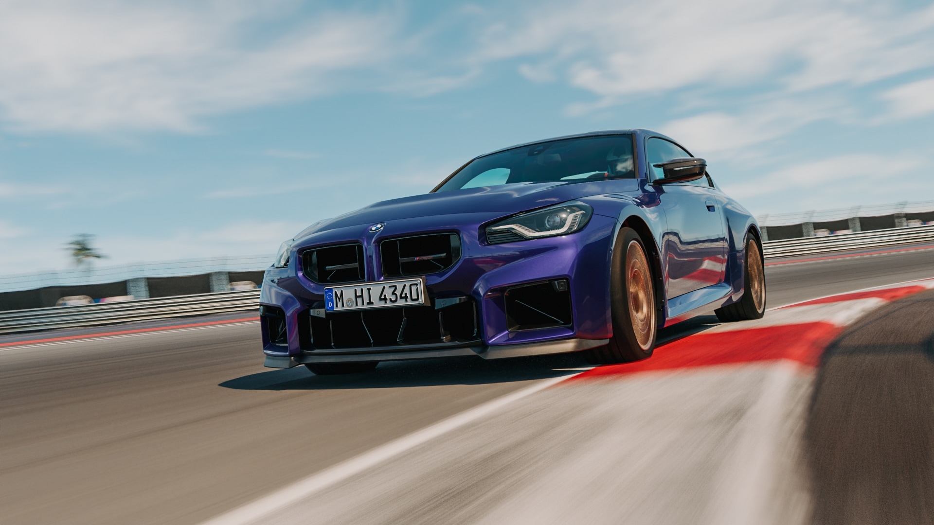 BMW M2 CS in Velvet Blue metallic driving on a racetrack