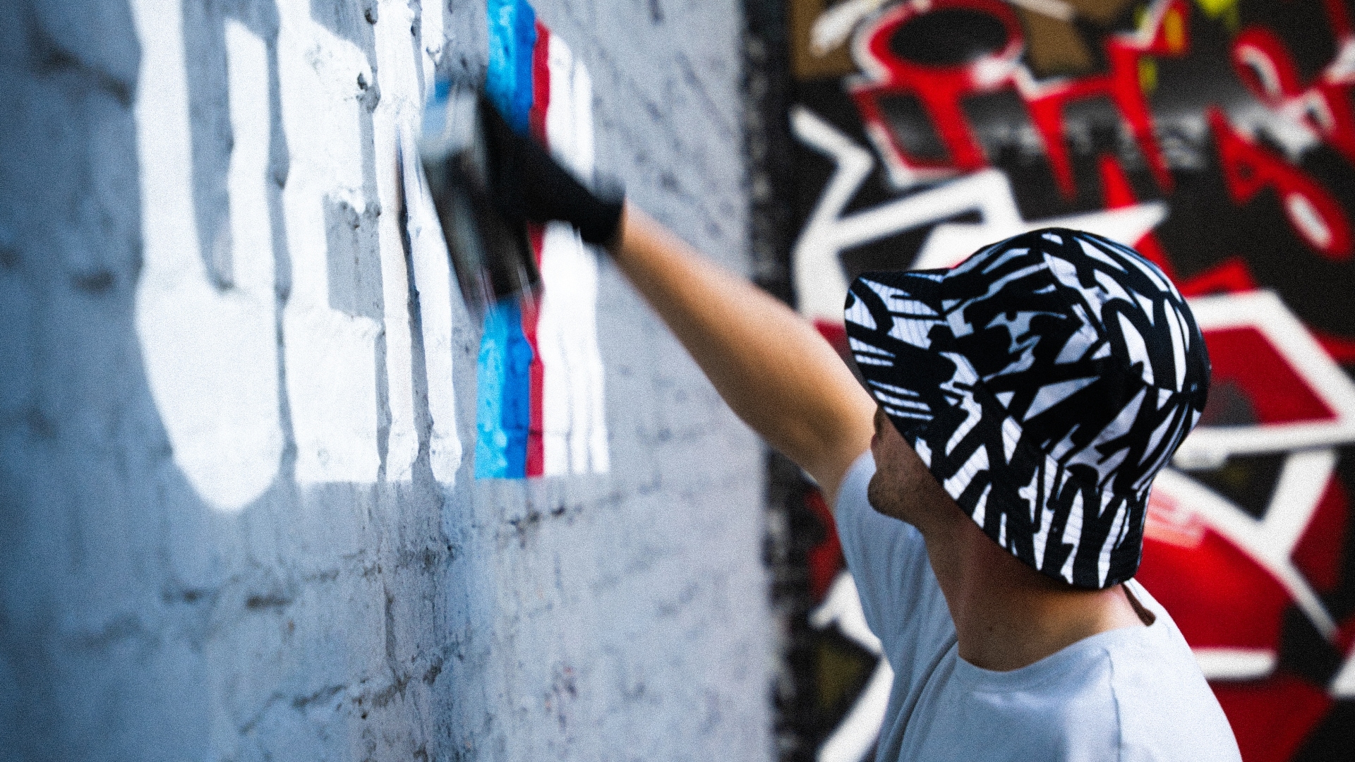 Artist Fillin Guas spraying the GEN M tag on a wall