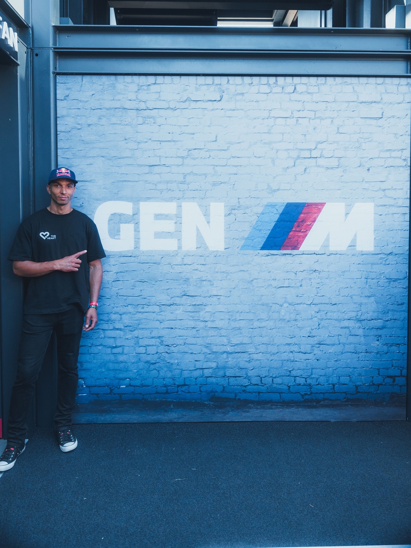 Elias Hountondji of the Drift Brothers leaning underneath the GEN-M-Logo at Goodwood.