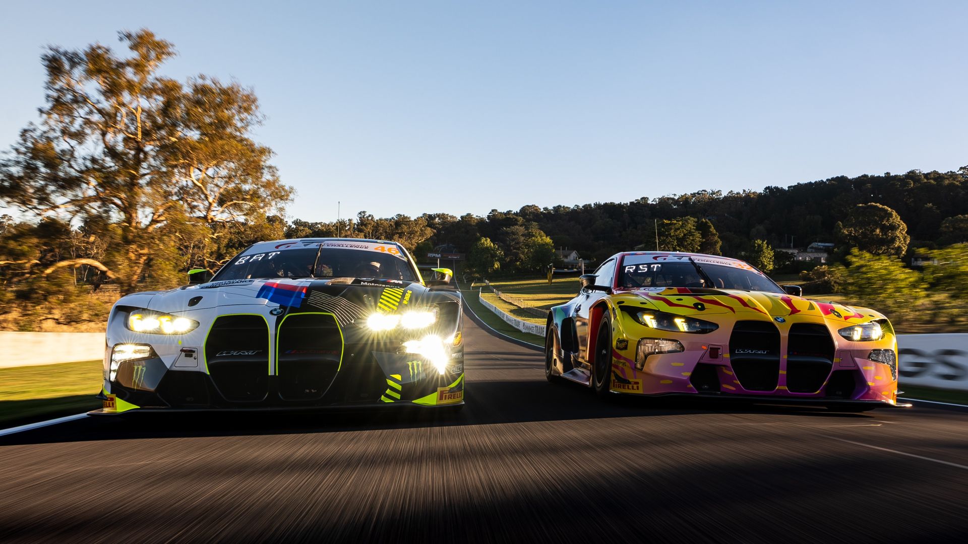 Two BMW M4 GT3 EVO at full speed on the racetrack at Bathurst.